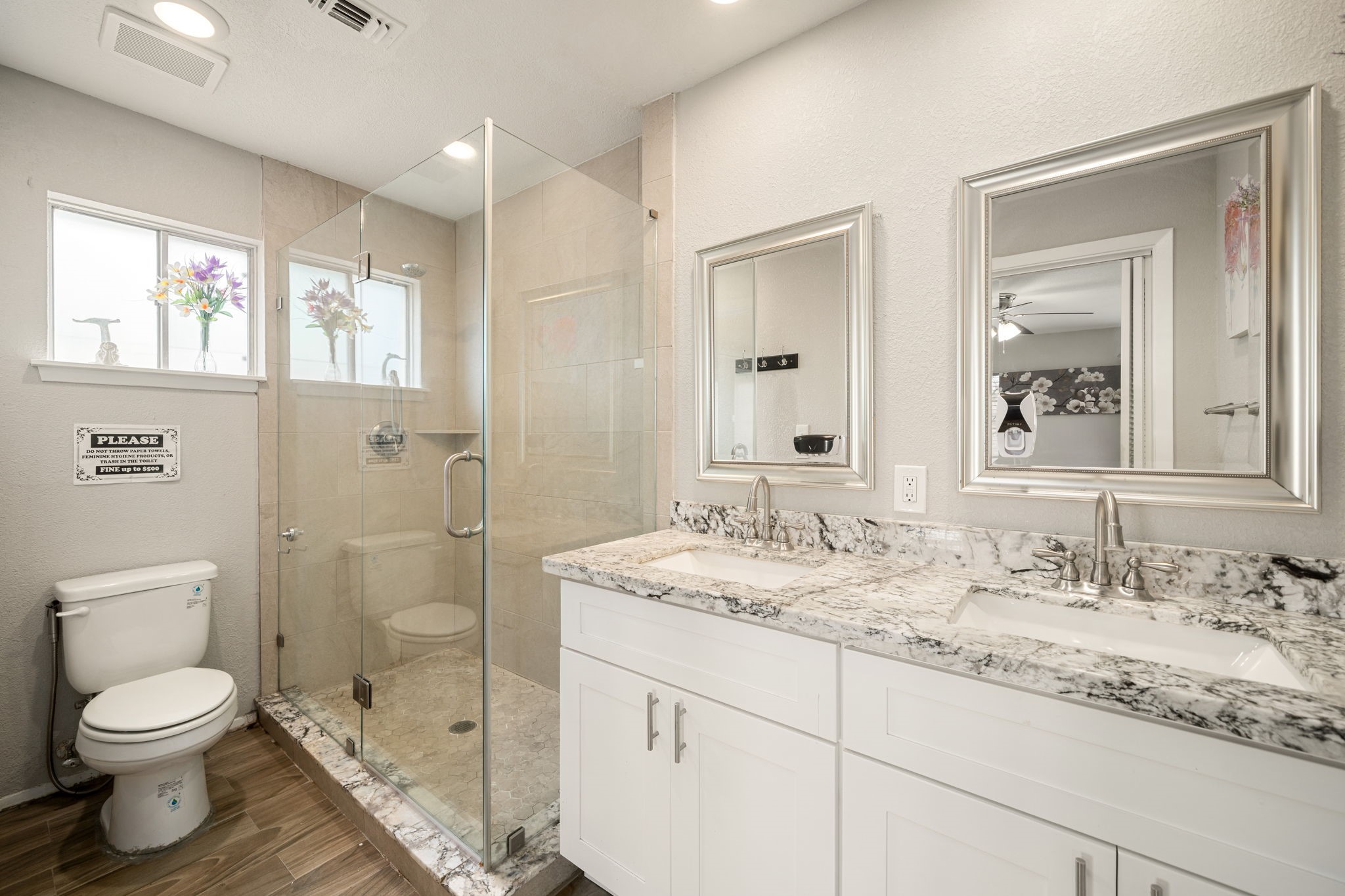 9019 Grape Street Houston, TX 77036 - Photo 13 of 24 a bathroom with a granite countertop toilet a sink a shower and a mirror