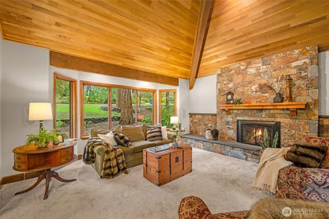 a living room with furniture a fireplace and a floor to ceiling window