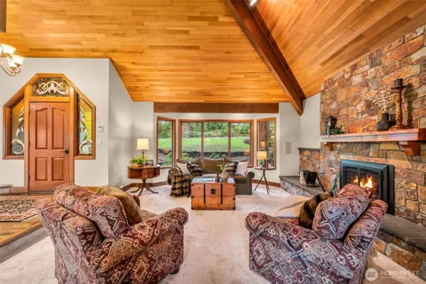 a living room with furniture fireplace and a large window