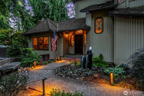 a front view of a house with porch and chairs