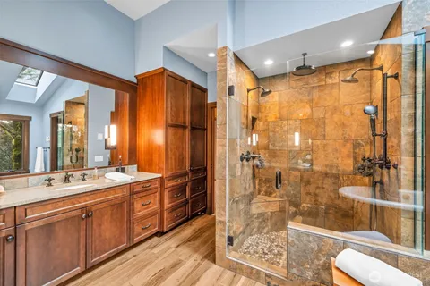 a bathroom with a double vanity sink toilet and shower