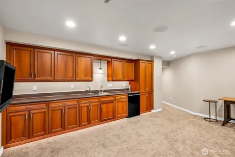 a large kitchen with stainless steel appliances granite countertop a sink and cabinets