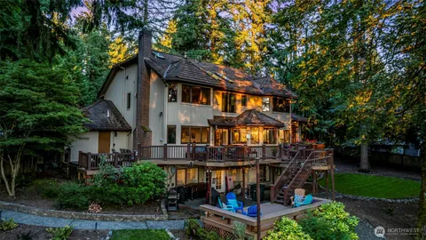 a view of house with a big yard plants and large trees