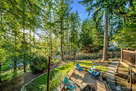a view of swimming pool with lawn chairs and plants