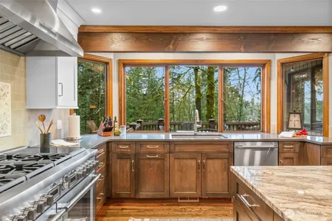 a kitchen with a stove a sink and next to a window