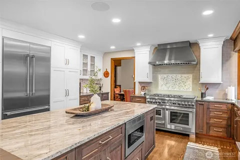 a kitchen with stainless steel appliances kitchen island granite countertop a stove and a sink