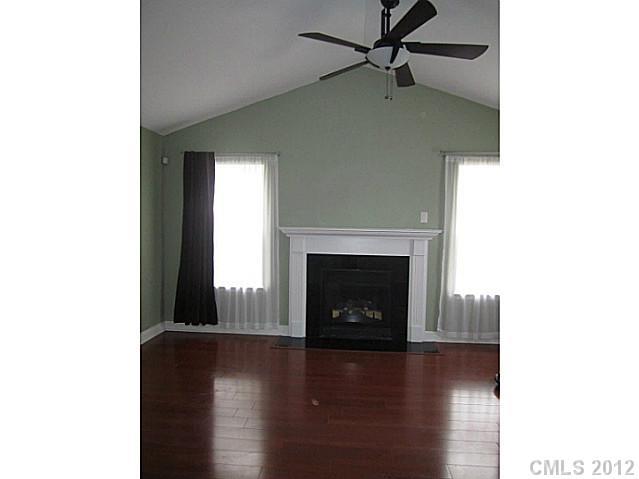 4908 Elizabeth Road Charlotte, NC 28269 - Photo 3 of 16 a living room with a fireplace and a wooden floor