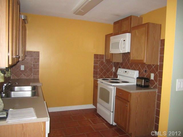 4908 Elizabeth Road Charlotte, NC 28269 - Photo 6 of 16 a view of a kitchen with fridge and wooden floor