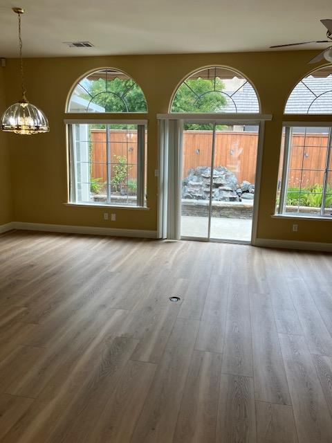 2157 West Rue St Michel Fresno, CA 93711 - Photo 4 of 22 an empty room with wooden floor and windows
