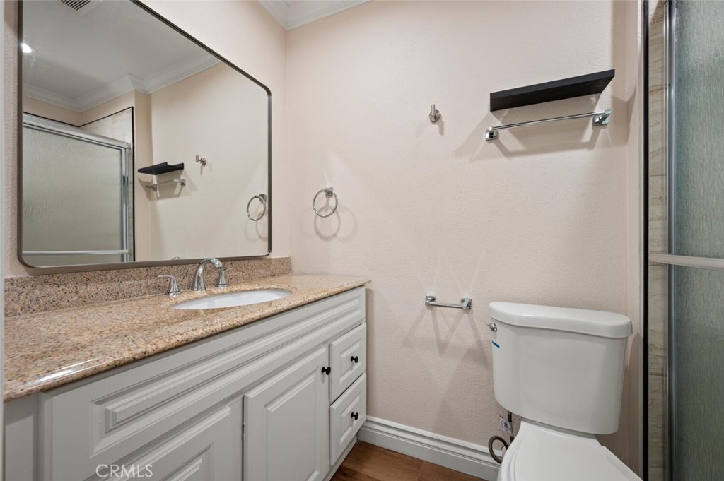 300 Cagney Lane, Unit 102 Newport Beach, CA 92663 - Photo 15 of 28 a bathroom with a granite countertop sink toilet and shower