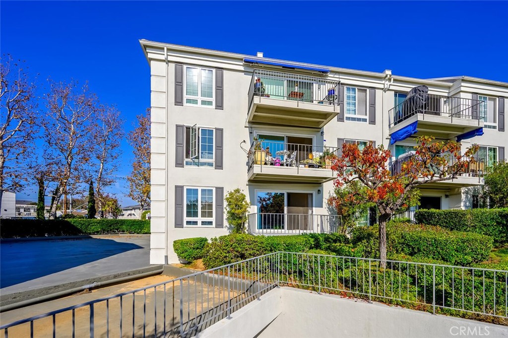 300 Cagney Lane, Unit 102 Newport Beach, CA 92663 - Photo 2 of 28 a view of a brick building next to a yard