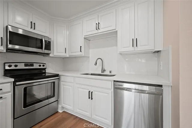 a kitchen with white cabinets and stainless steel appliances