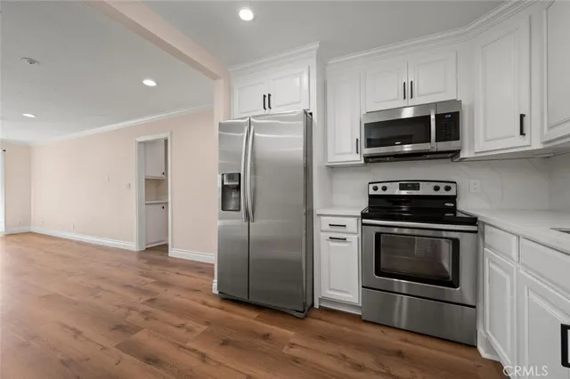 a kitchen with stainless steel appliances granite countertop a refrigerator stove and microwave