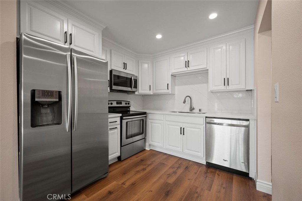 300 Cagney Lane, Unit 102 Newport Beach, CA 92663 - Photo 9 of 28 a kitchen with a refrigerator stove and sink