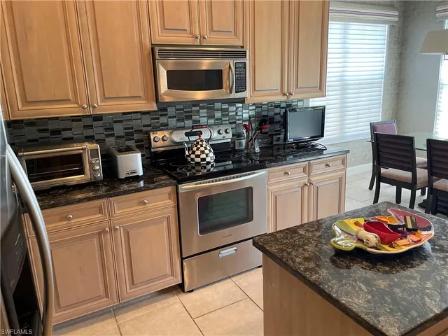 a kitchen with stainless steel appliances granite countertop a sink stove and microwave