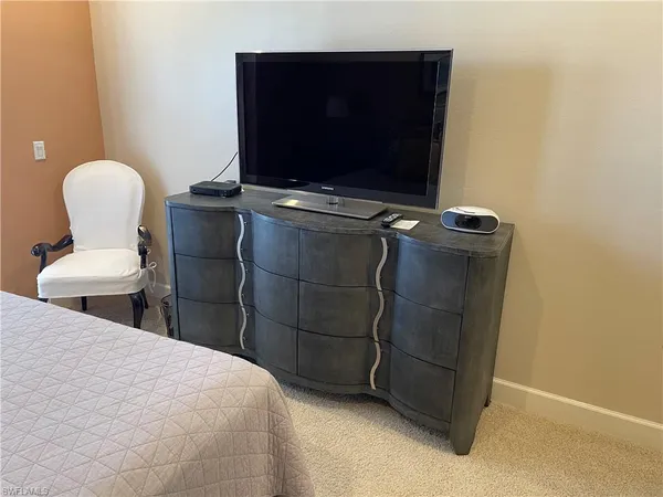 a bedroom with a bed and a television