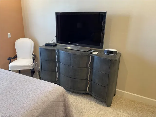 a bedroom with a bed and a television