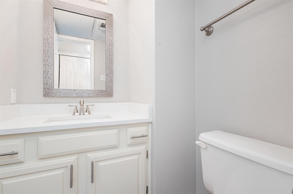18240 Midway Road, Unit 204 Dallas, TX 75287 - Photo 13 of 21 a bathroom with a sink a toilet and a mirror