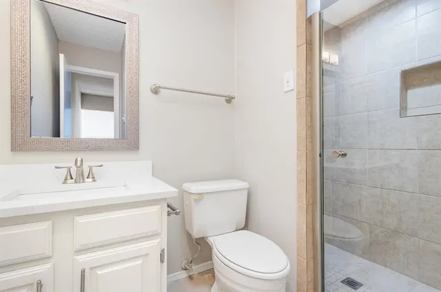 a bathroom with a toilet sink vanity and mirror