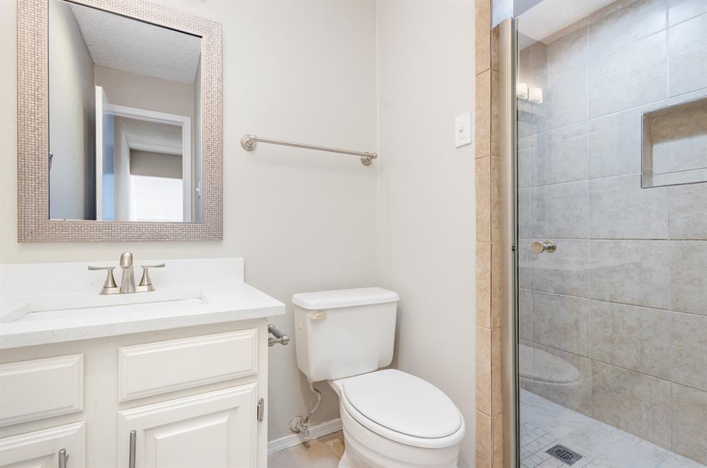 18240 Midway Road, Unit 204 Dallas, TX 75287 - Photo 17 of 21 a bathroom with a toilet sink vanity and mirror