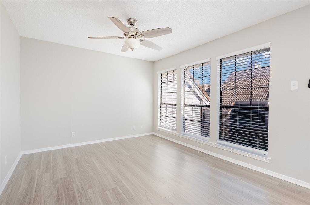 18240 Midway Road, Unit 204 Dallas, TX 75287 - Photo 18 of 21 a view of an empty room with a window and wooden floor