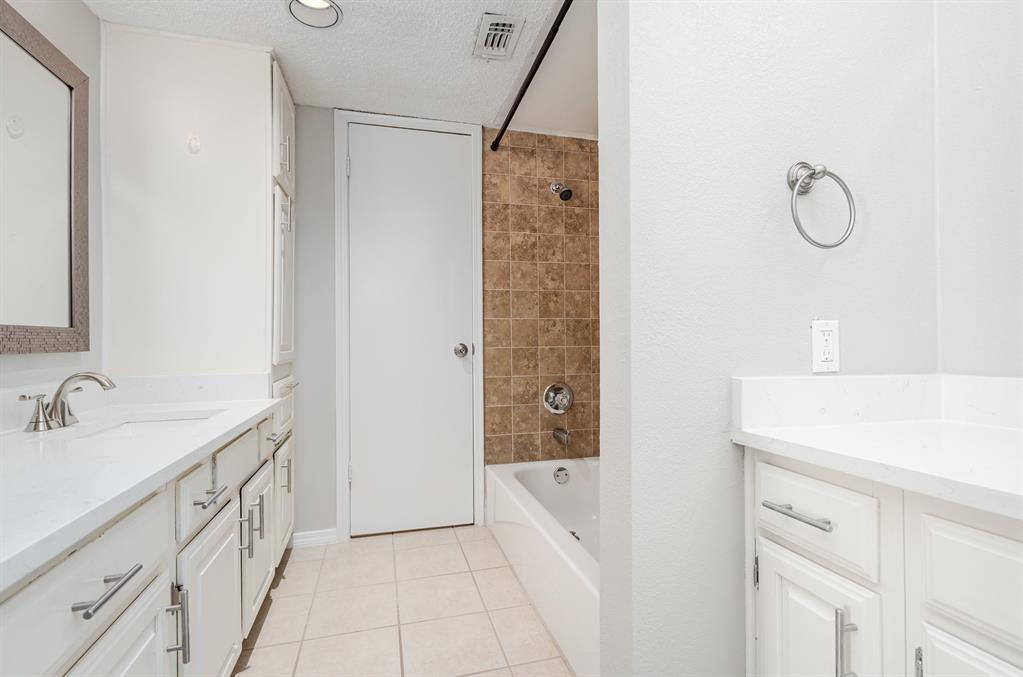 18240 Midway Road, Unit 204 Dallas, TX 75287 - Photo 20 of 21 a bathroom with a double vanity sink and mirror
