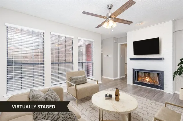 a living room with furniture a flat screen tv and a fireplace