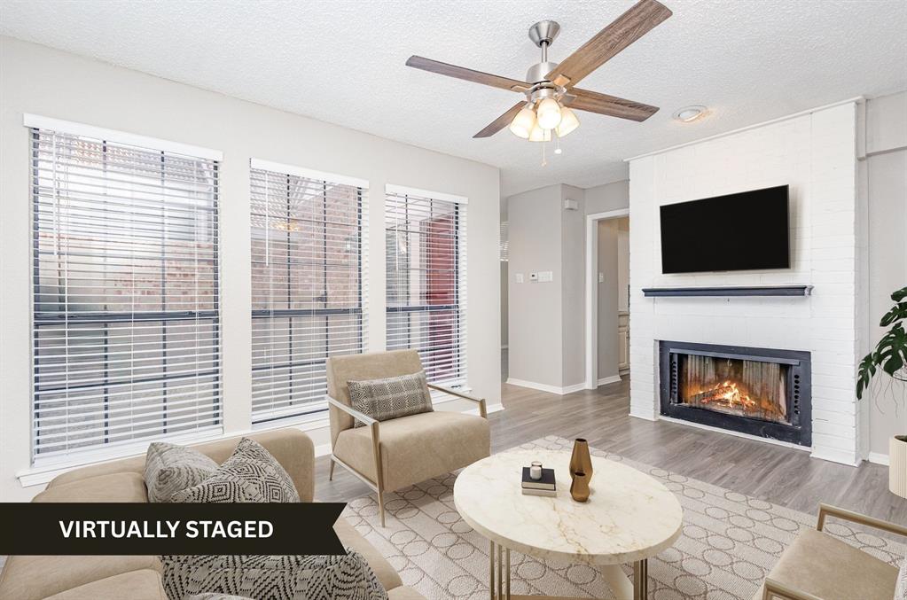 18240 Midway Road, Unit 204 Dallas, TX 75287 - Photo 6 of 21 a living room with furniture a flat screen tv and a fireplace