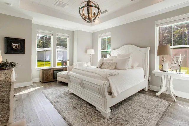 a bedroom with a bed a dresser and next to a window