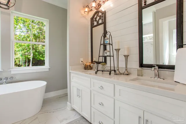a bathroom with a double vanity sink a mirror and a bathtub