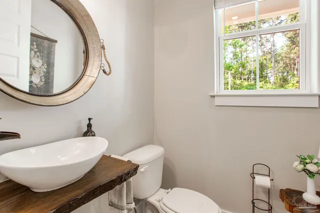 a bathroom with a toilet a sink and a mirror