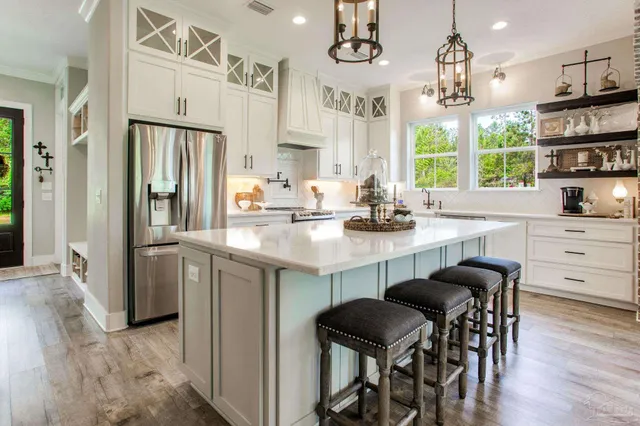 a kitchen with stainless steel appliances granite countertop a table chairs and a refrigerator