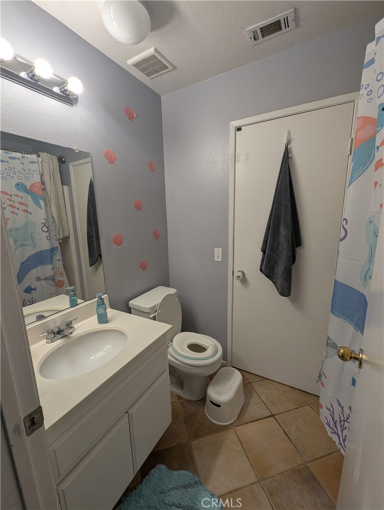 44601 Crestwood Circle Temecula, CA 92592 - Photo 22 of 46 a bathroom with a toilet sink and mirror