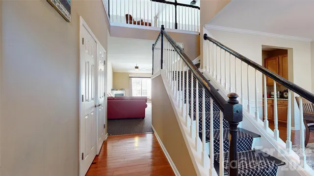 a view of a hallway with wooden floor and stairs