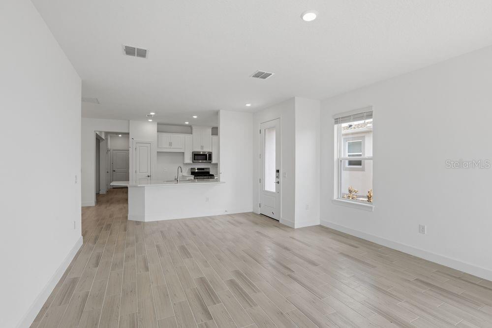 5375 Spoonflower Court St. Cloud, FL 34771 - Photo 11 of 42 an empty room with wooden floor and windows