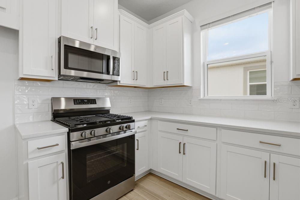 5375 Spoonflower Court St. Cloud, FL 34771 - Photo 3 of 42 a kitchen with white cabinets and stainless steel appliances