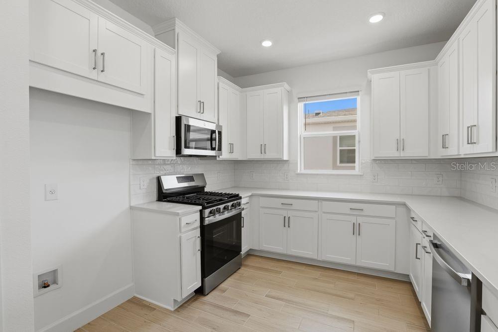 5375 Spoonflower Court St. Cloud, FL 34771 - Photo 5 of 42 a kitchen with stainless steel appliances granite countertop a stove a sink and a microwave