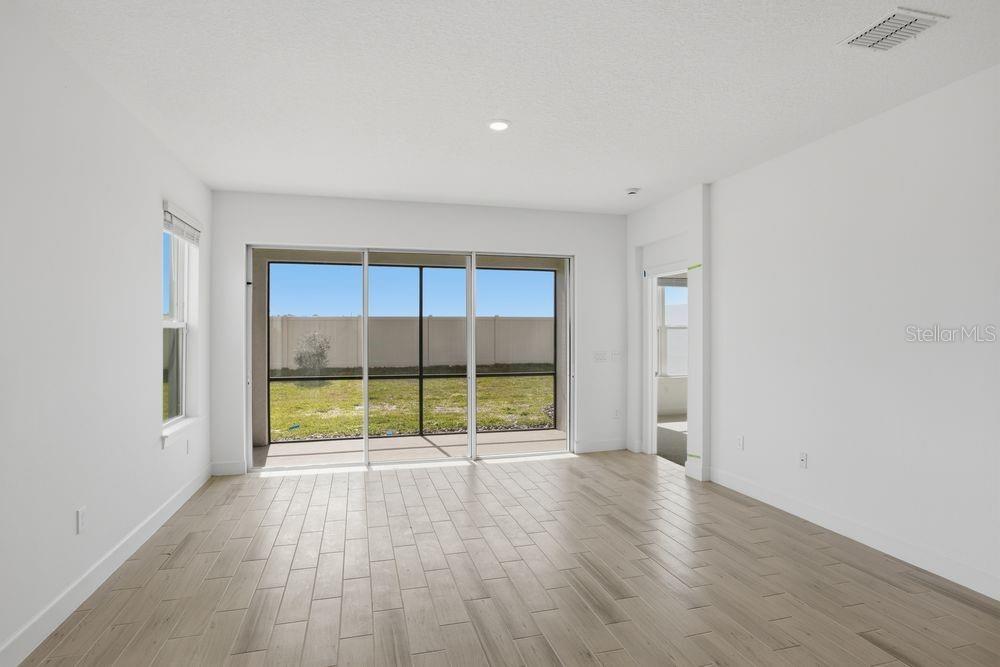 5375 Spoonflower Court St. Cloud, FL 34771 - Photo 9 of 42 an empty room with wooden floor and a fireplace