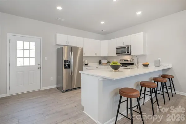 a kitchen with stainless steel appliances a refrigerator and a stove top oven