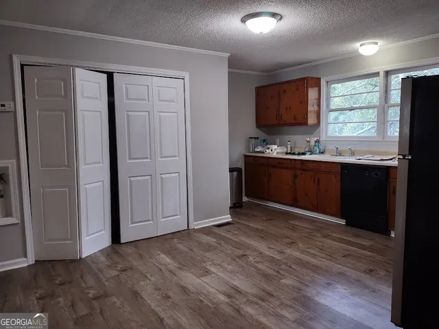 a view of kitchen with kitchen island granite countertop cabinets and refrigerator