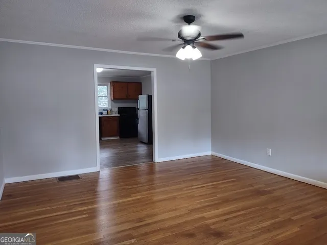 a view of an empty room with wooden floor
