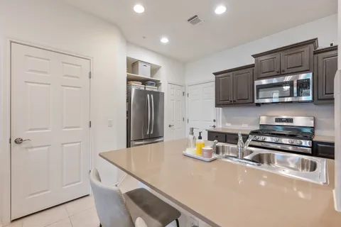a kitchen with stainless steel appliances a refrigerator a stove a sink a microwave and cabinets