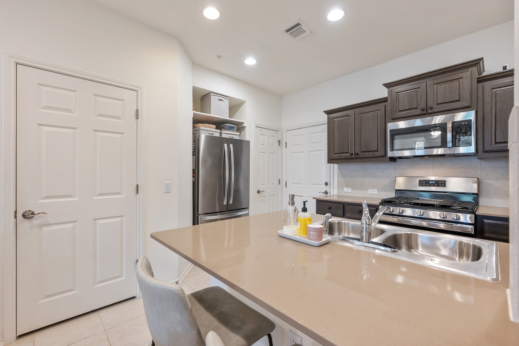 4400 Vaughan Street, Unit B Austin, TX 78723 - Photo 11 of 29 a kitchen with stainless steel appliances a refrigerator a stove a sink a microwave and cabinets