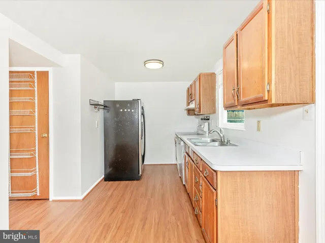 a kitchen with a sink a refrigerator and a window