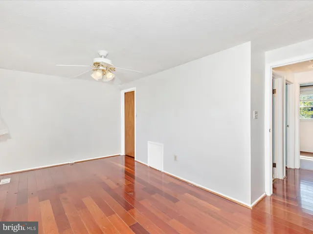 an empty room with wooden floor and window