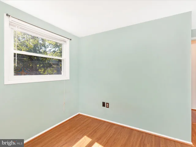 a view of a small space with wooden floor and a window
