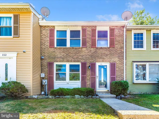 a front view of brick house with a yard and outdoor seating