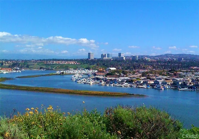 a view of a city with lots of residential buildings ocean and mountain view in back