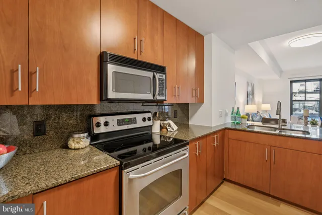a kitchen with stainless steel appliances granite countertop a sink stove and microwave