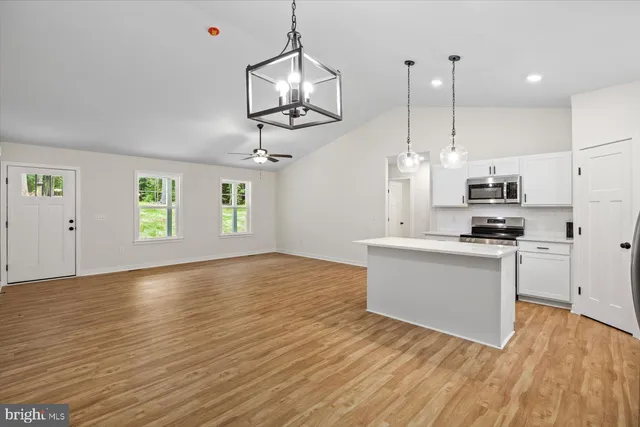 an open kitchen with kitchen island white cabinets and stainless steel appliances